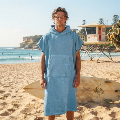 Man wearing a two-tone blue surf poncho towel at the beach – ShowerNest