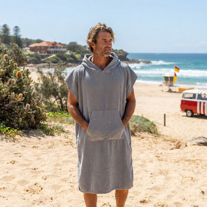 Man wearing a grey surf poncho towel at the beach – ShowerNest