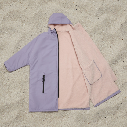 Lilac and pink surf changing robe laid flat on sand – ShowerNest Australia