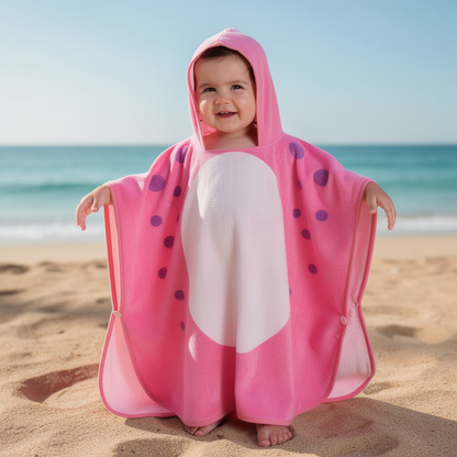 Child in a pink dinosaur hooded towel on the beach – ShowerNest Australia