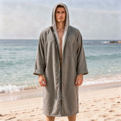 Man wearing a grey hooded surf changing robe on the beach – ShowerNest Australia