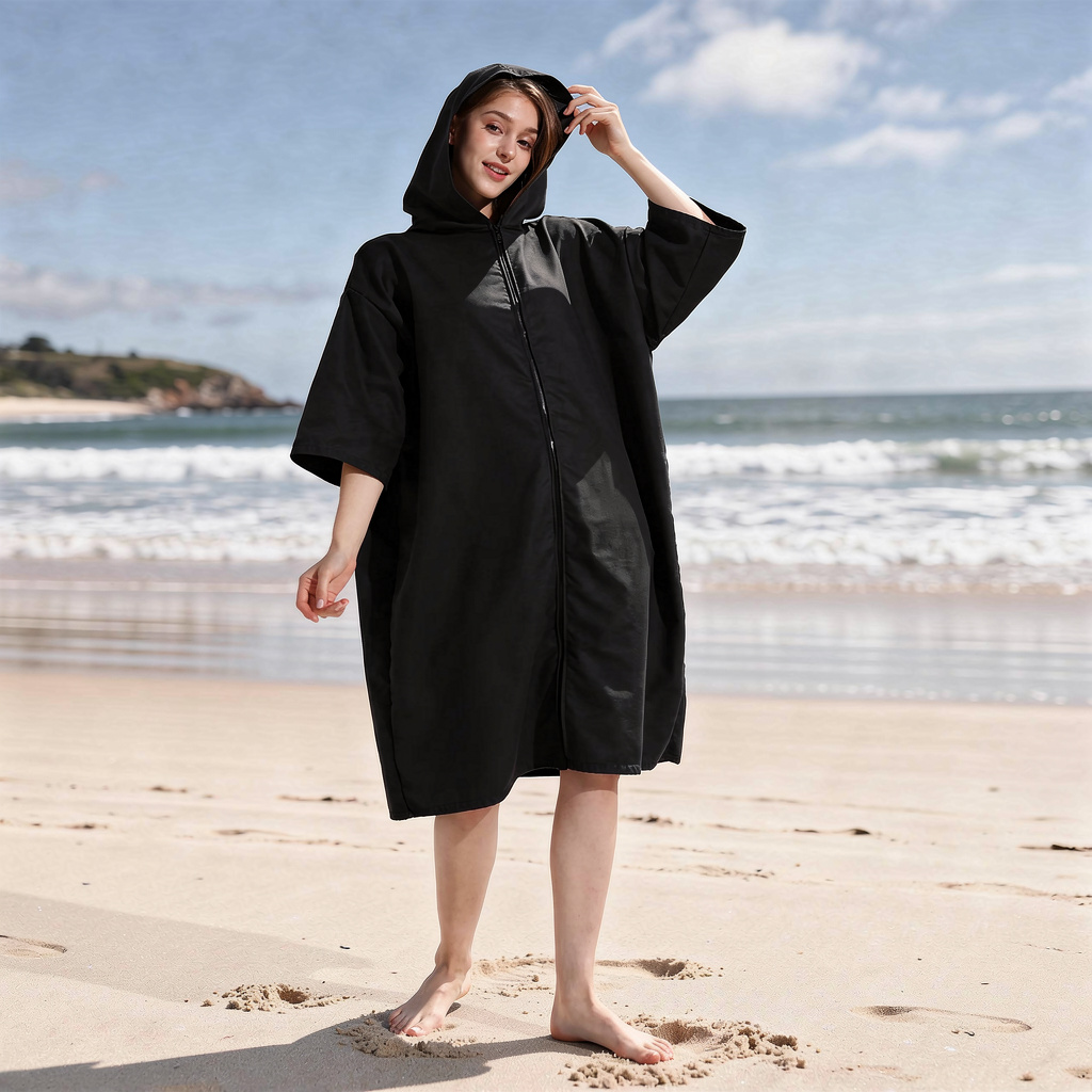 Black zip-up hooded changing robe with sleeves worn on the beach – ShowerNest Australia