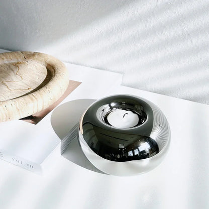Polished silver candle holder on a bathroom shelf