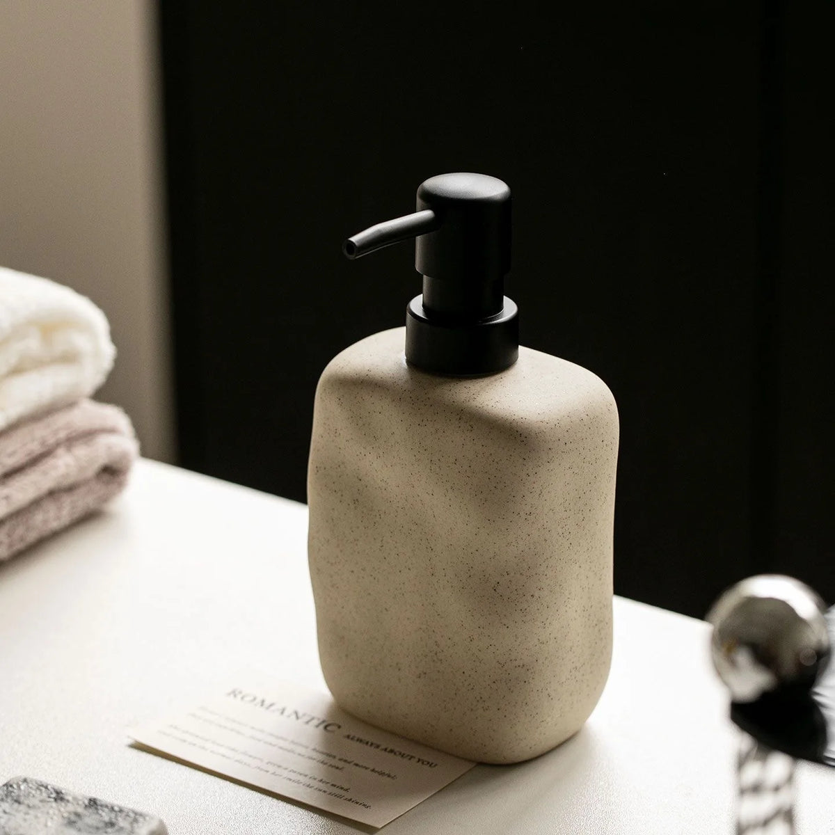 Textured cream ceramic soap dispenser on a bathroom vanity