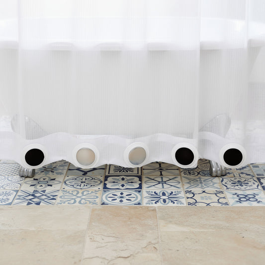 Magnetic weights holding the hem of a shower curtain