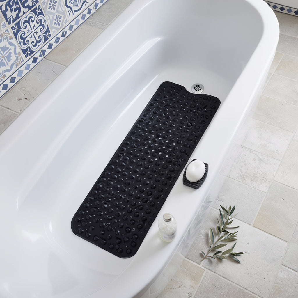 Black non slip bath mat with suction cups inside a bathtub
