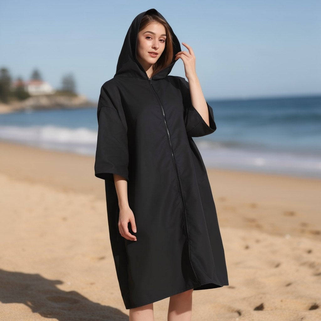 Black hooded changing robe with sleeves worn by the sea – ShowerNest Australia