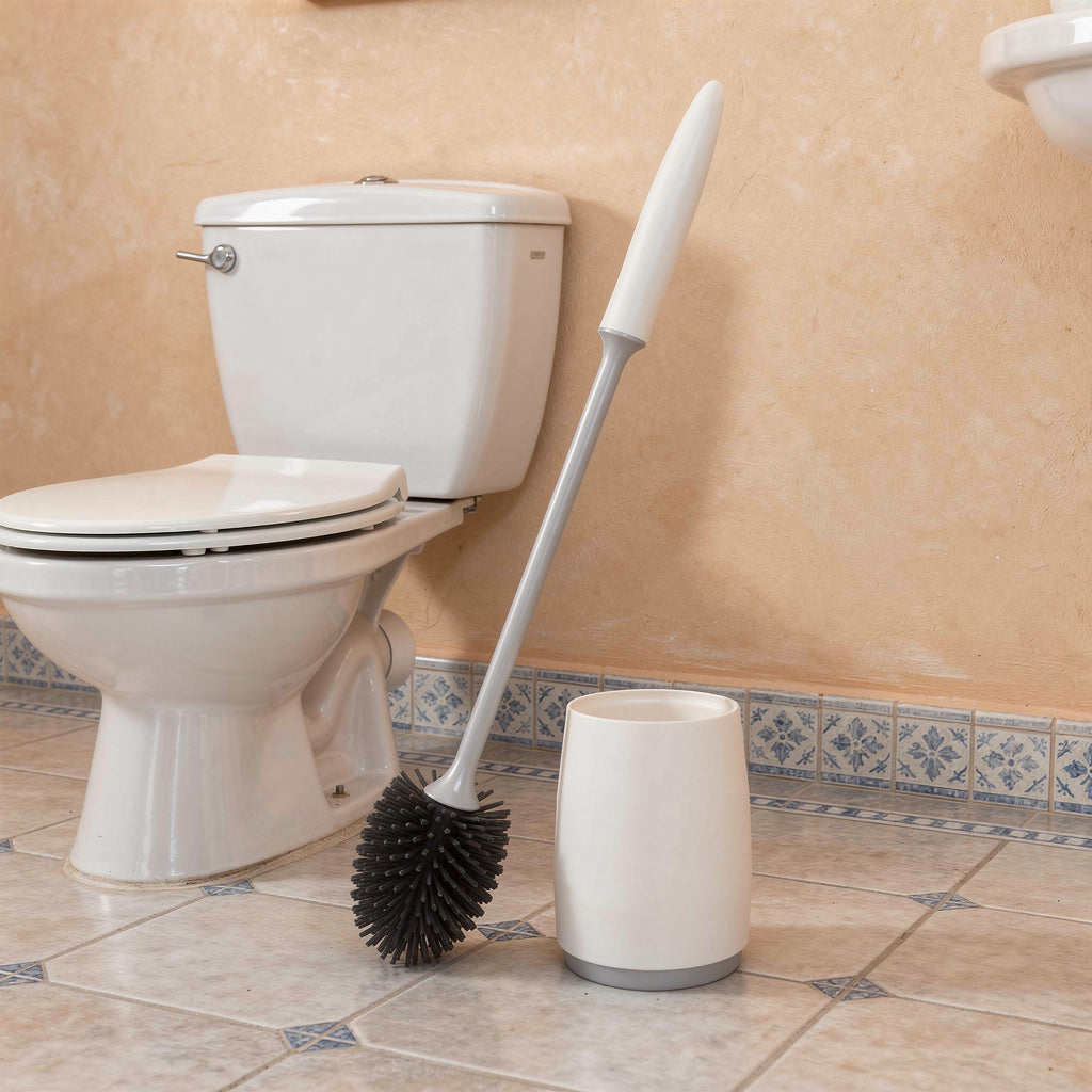 White silicone toilet brush and holder next to a toilet